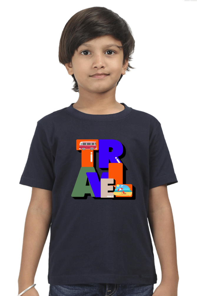 A young child with short dark hair wears a trendy TuckTribe TRAVEL BOYS T-SHIRT, featuring TRAVEL in block letters on navy blue, each adorned with transport or globe-trotting symbols against a plain white background.