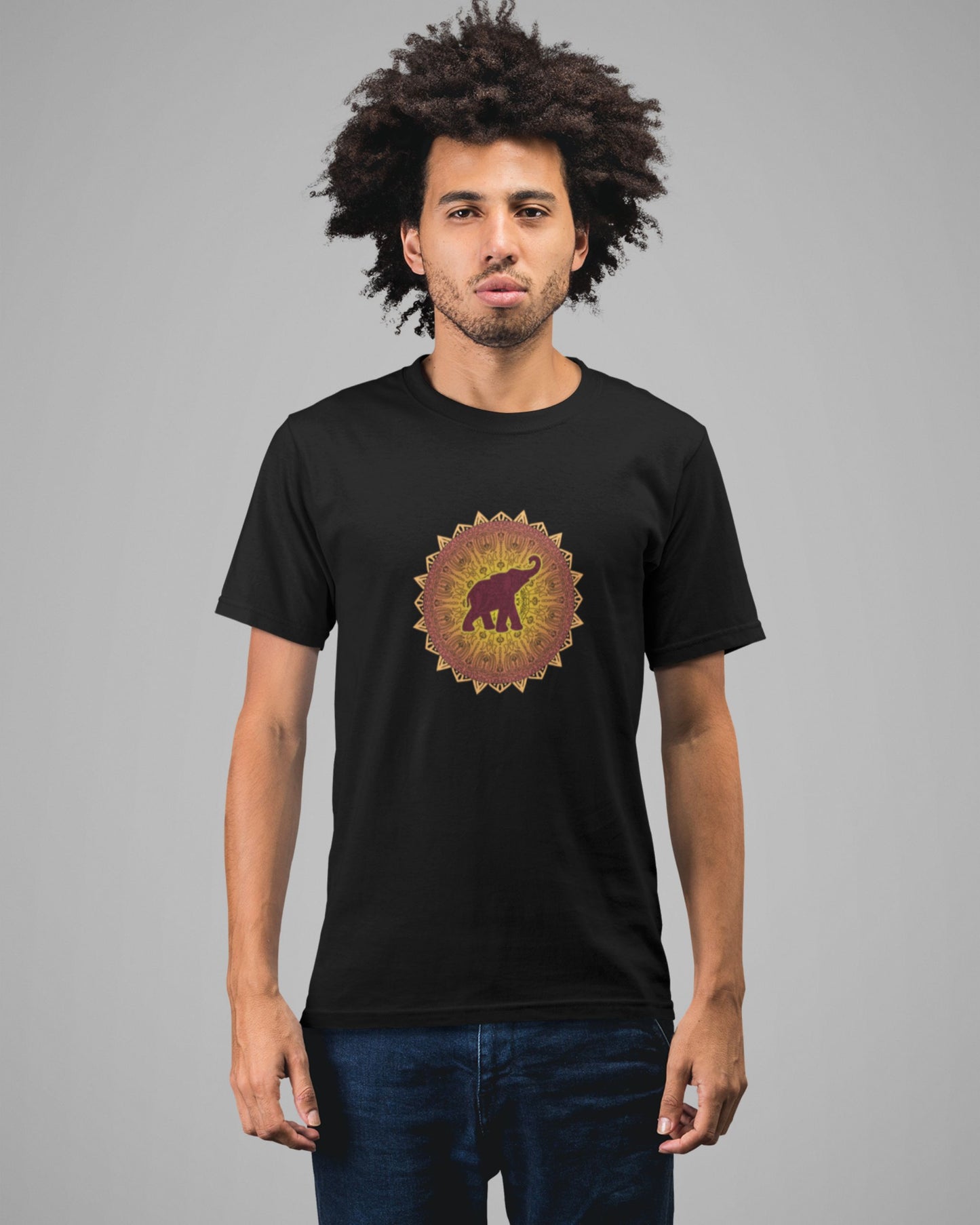 Man wearing a black tucktribe t-shirt with a colorful mandala elephant design on a gray background