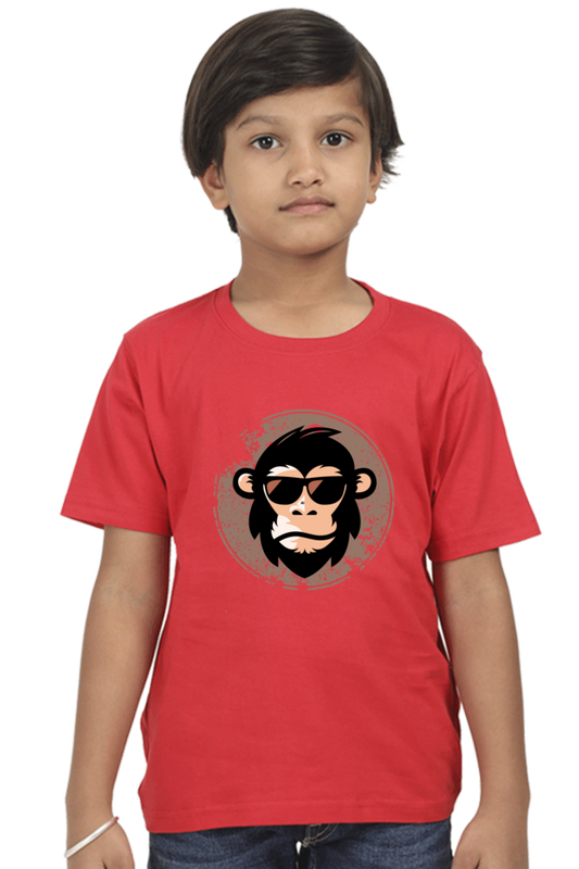 A young child with short brown hair stands against a white background, wearing the TuckTribe COOL CHIMP BOYS T-SHIRT featuring a chimpanzee with sunglasses.