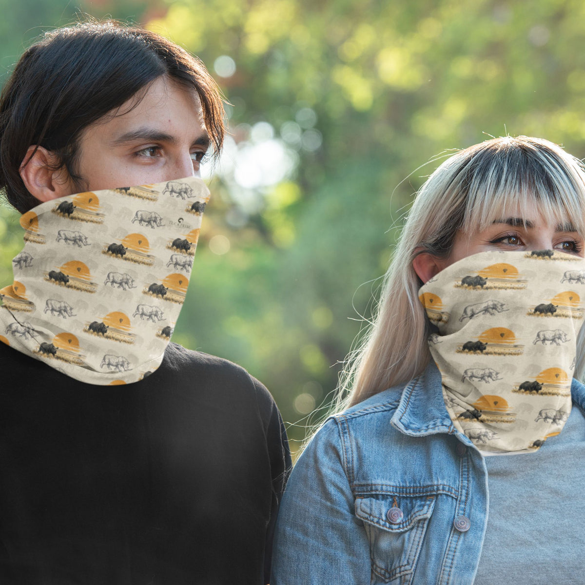 Two people outdoors wearing beige face masks with a repeating rhinoceros print. 