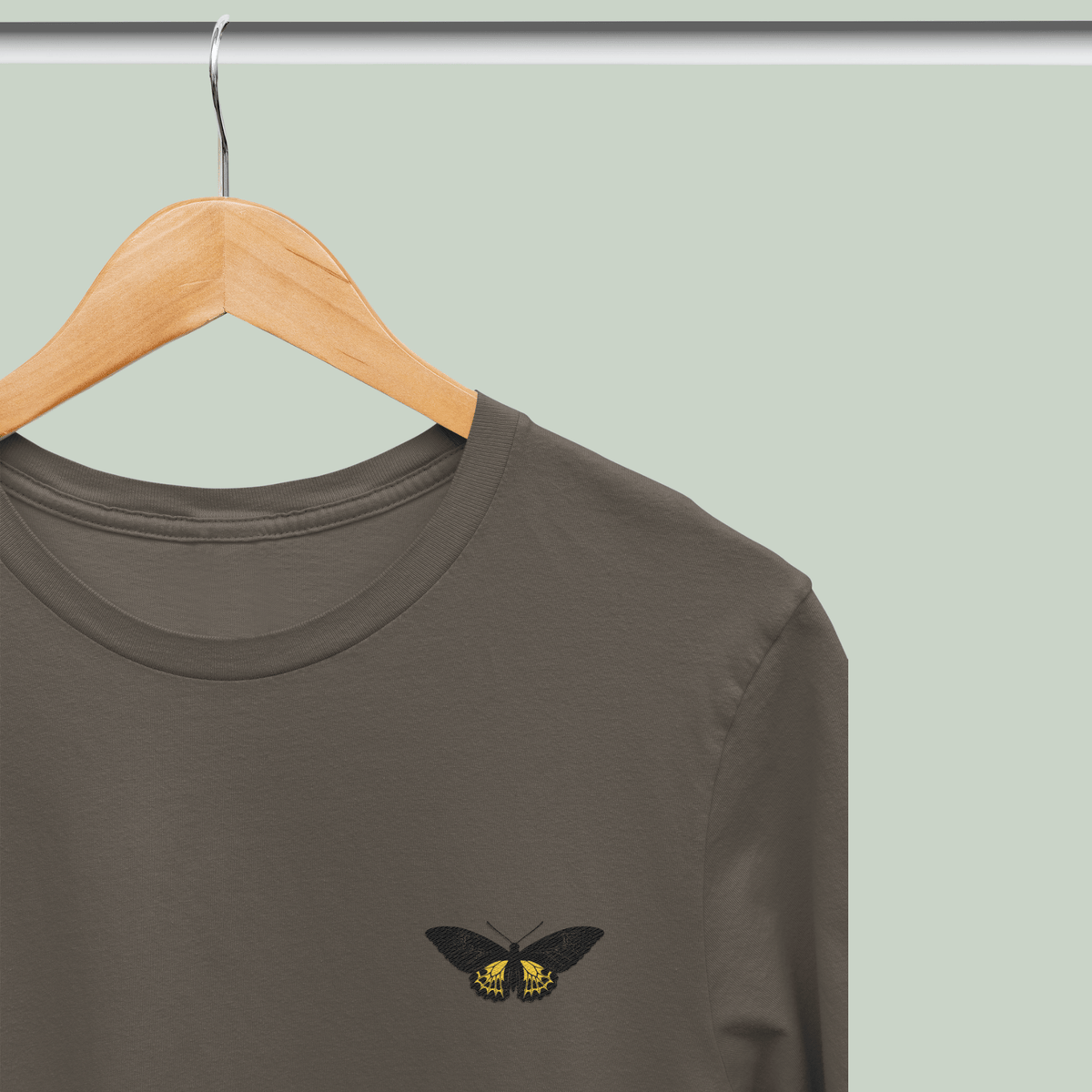 Southern Birdwing butterfly-wing embroidery design in golden yellow on a black T-shirt by Tucktribe.