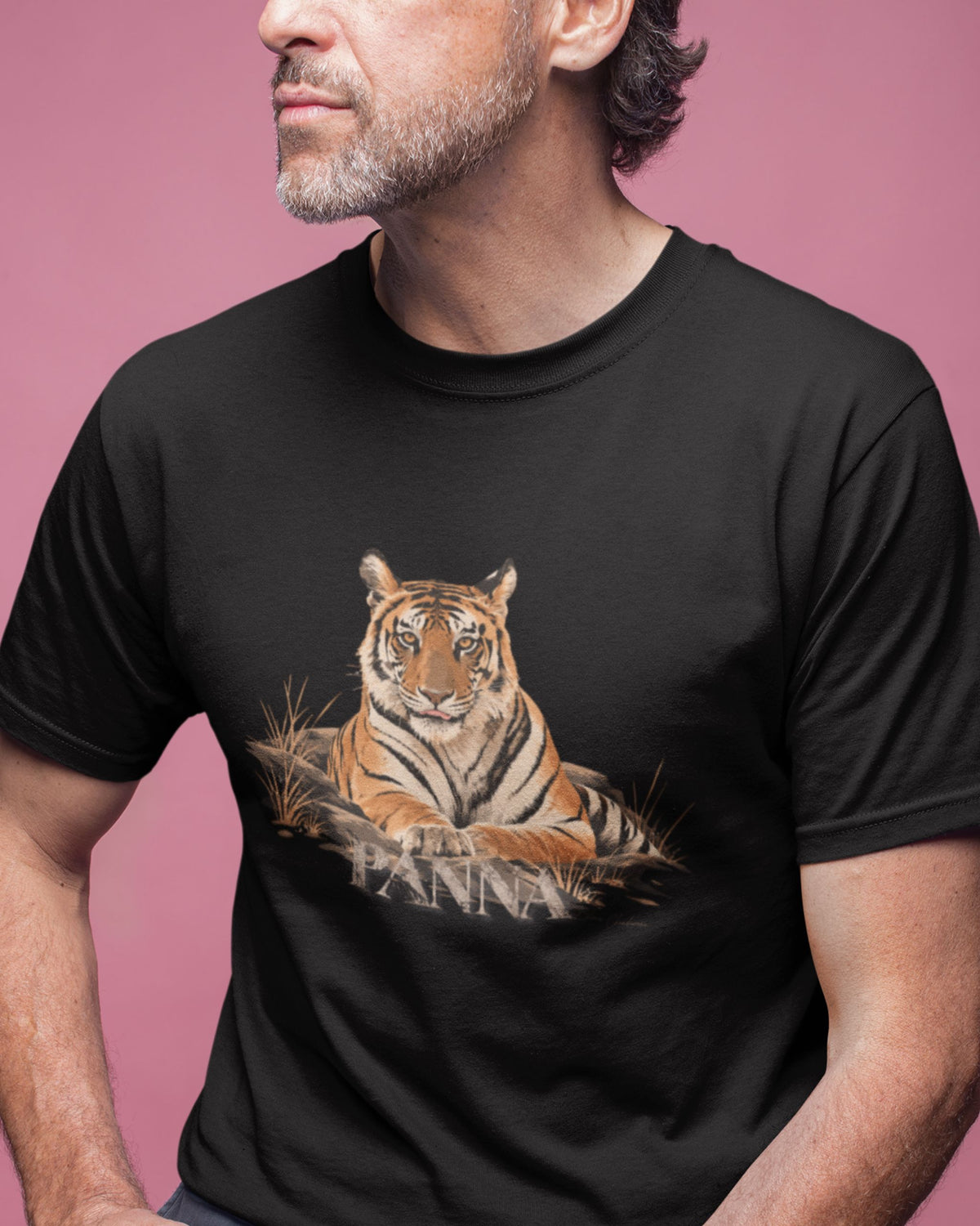 man wearing a Queen of Panna Bengal tiger graphic on black unisex T-shirt by Tucktribe with a pink background