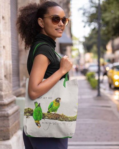 Woman holding a tucktribe tote bag with Brown Headed parrot design on a city street
