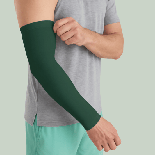 Person wearing a tucktribe forest green arm sleeve on a light green background