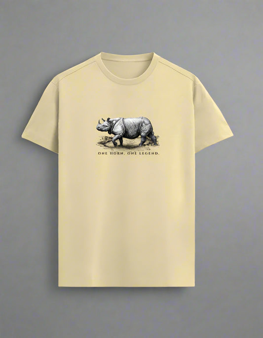 Beige T-shirt with hand-drawn rhino illustration and “One Horn. One Legend.” text, laid flat on a grey background