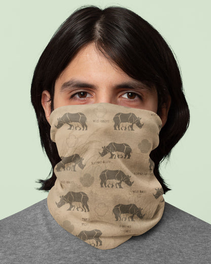 A person wearing a beige neck gaiter with a brown rhinoceros print, shown from the chest up against a pale green background.