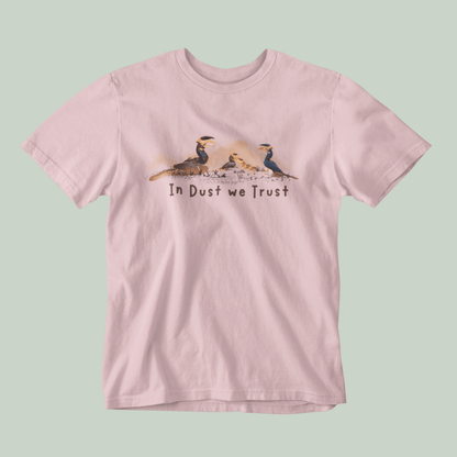 Pink t-shirt with graphic design and text 'In Dust We Trust' on a light green background