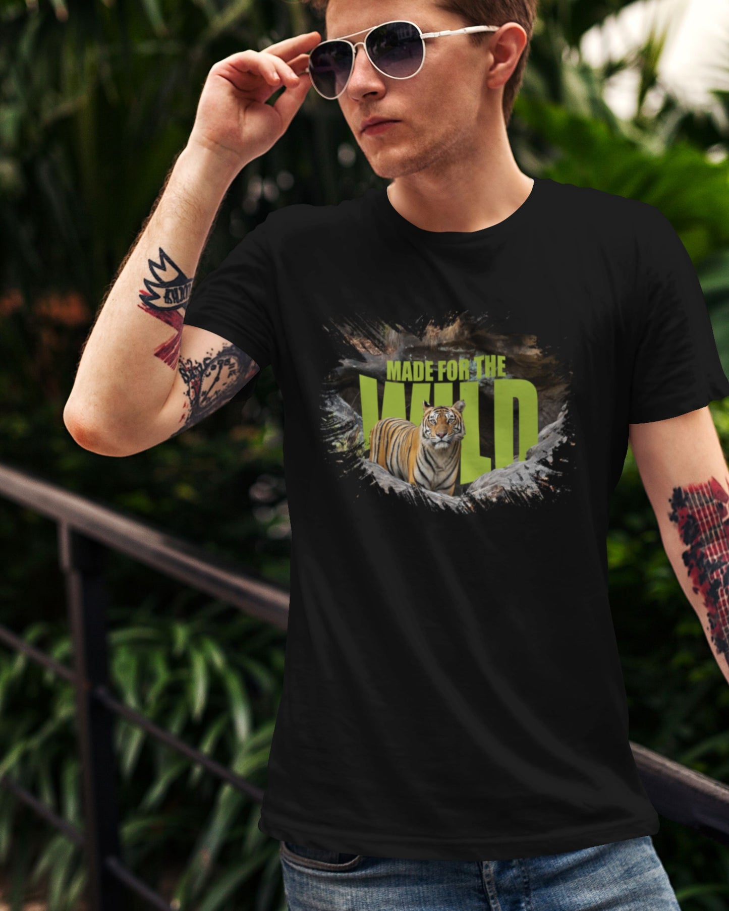 Person wearing a black t-shirt with a tiger graphic and 'Made for the Wild' text, outdoors.
