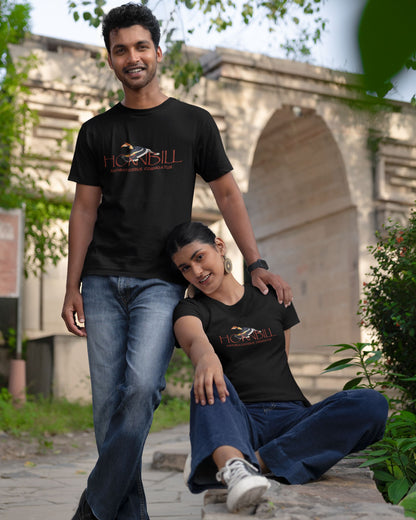 Two people wearing black tucktribe t-shirts with a hornbill design in front of a stone archway.