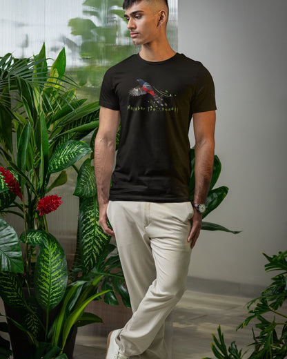 Man wearing a black t-shirt with a graphic design standing among plants.
