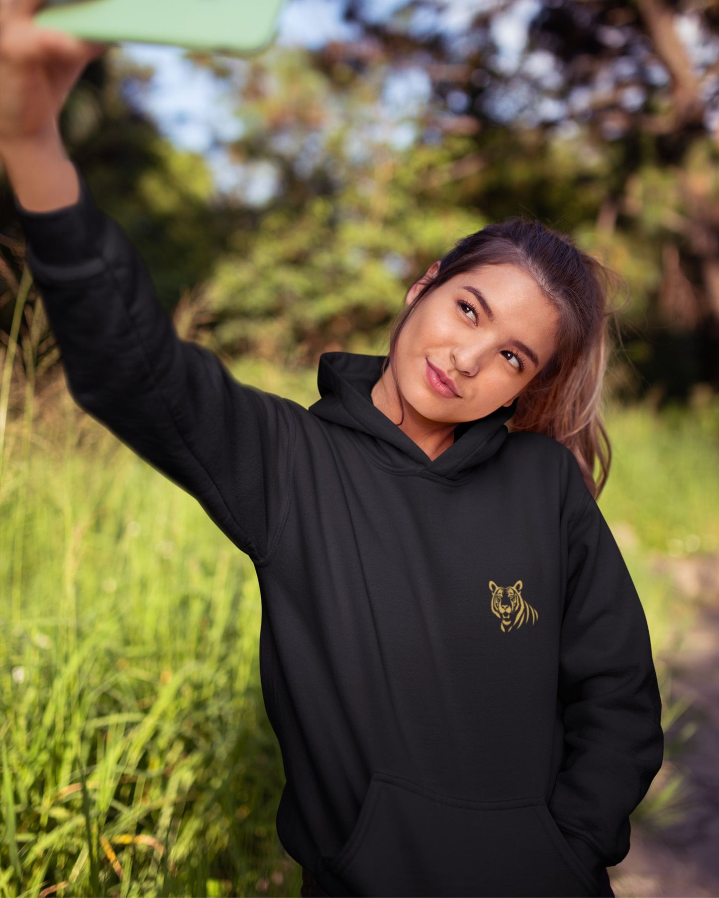 woman wearing a Minimal embroidered tiger embroidery on premium Tucktribe olive green unisex hoodie