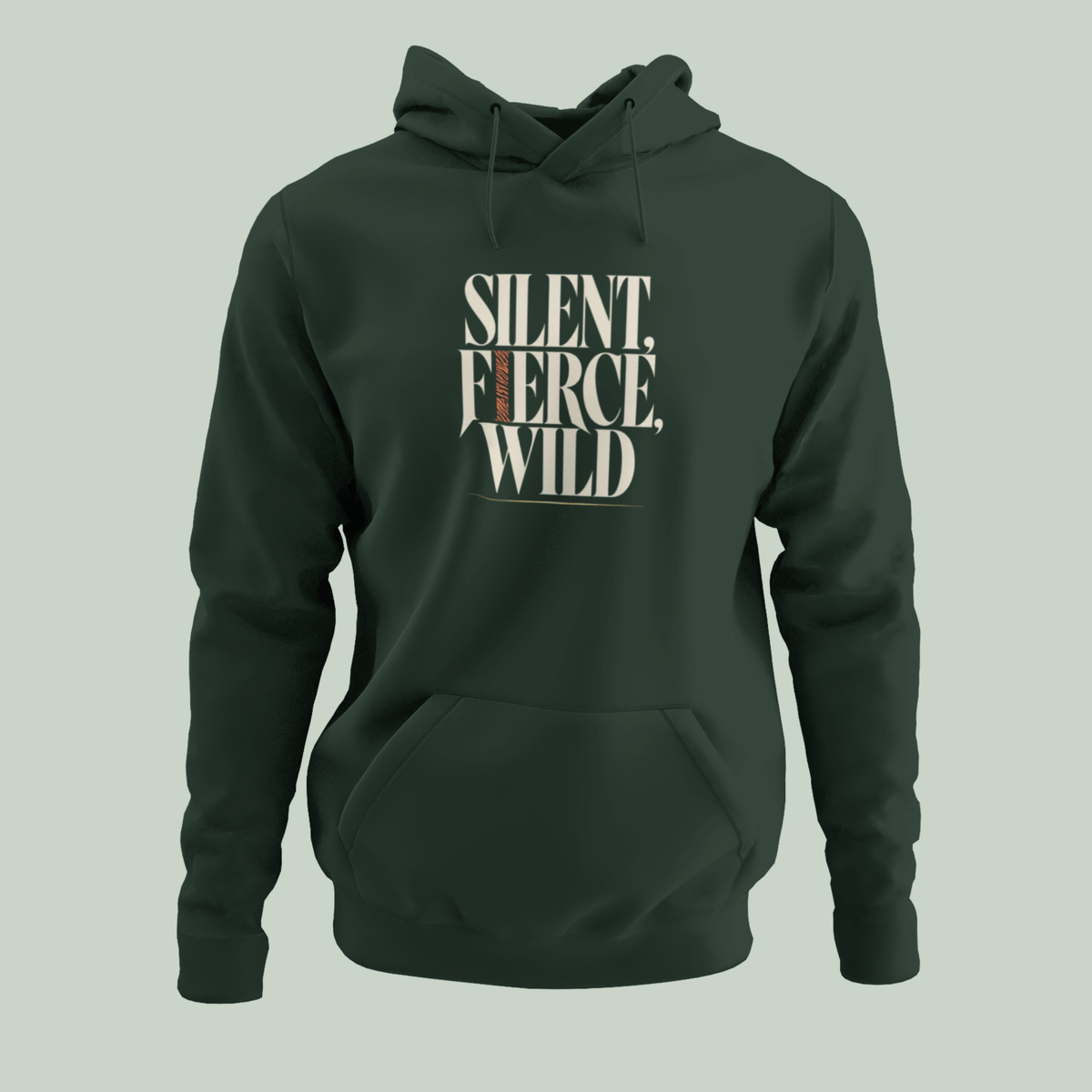 A dark forest green pullover hoodie with a front kangaroo pocket and drawstring hood, featuring the text 'SILENT, FIERCE, WILD' printed in a cream-colored stencil font on the chest. The hoodie is displayed on a solid light sage green background.