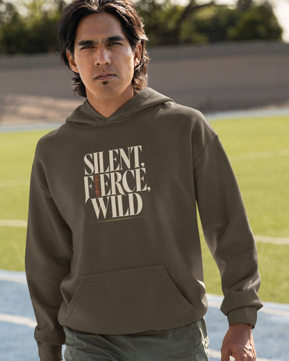 A man wearing an olive green hoodie with the text 'SILENT. FIERCE, WILD.