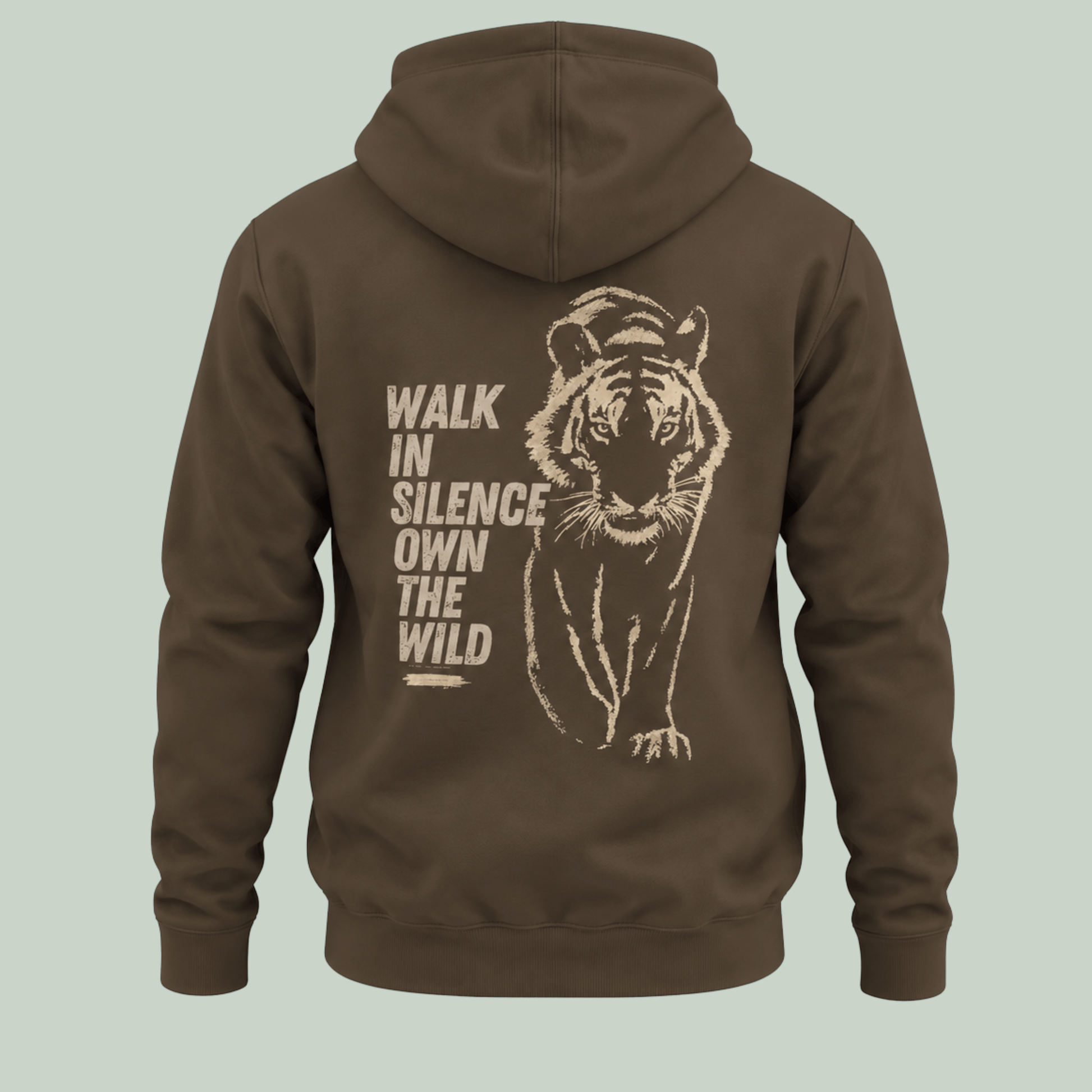 A Olive green pullover hoodie shown from the back, featuring a large beige graphic of a tiger and the text 'WALK IN SILENCE OWN THE WILD' printed on the back, set against a solid light sage green background.