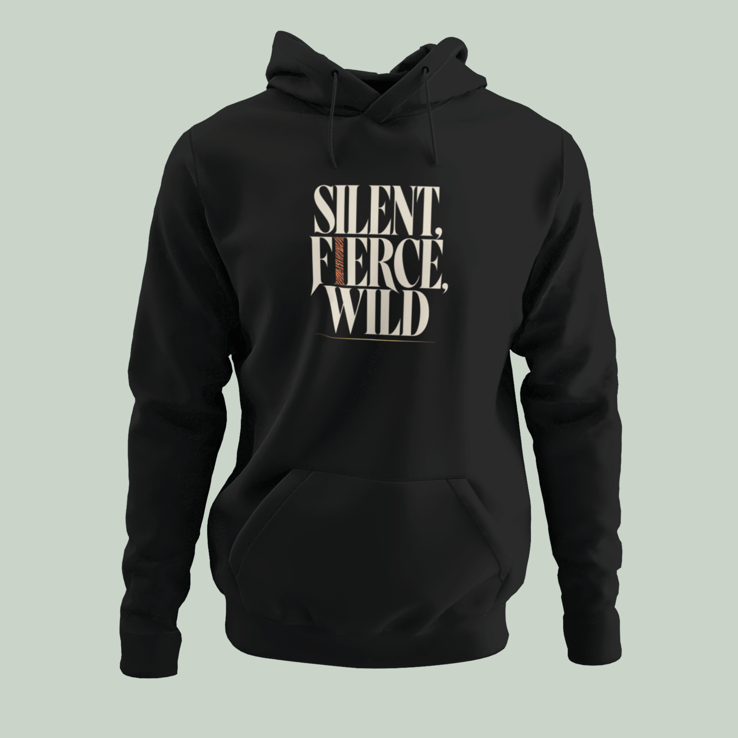 A black pullover hoodie with a front kangaroo pocket and drawstring hood, featuring the text 'SILENT, FIERCE, WILD' printed in a distressed cream and brown font on the chest, set against a solid pale sage green background.