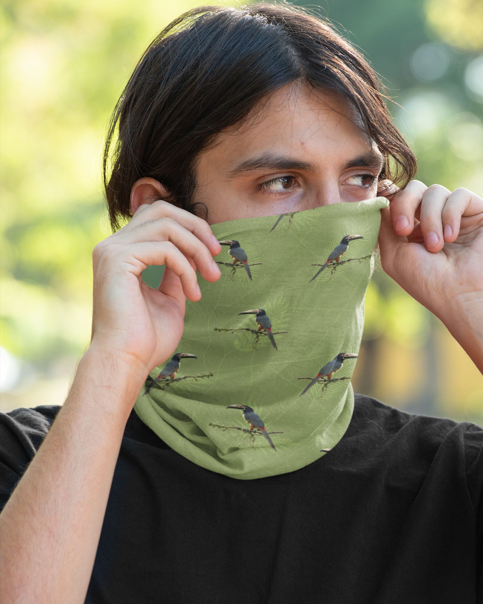 Person wearing a green neck gaiter with bird patterns outdoors