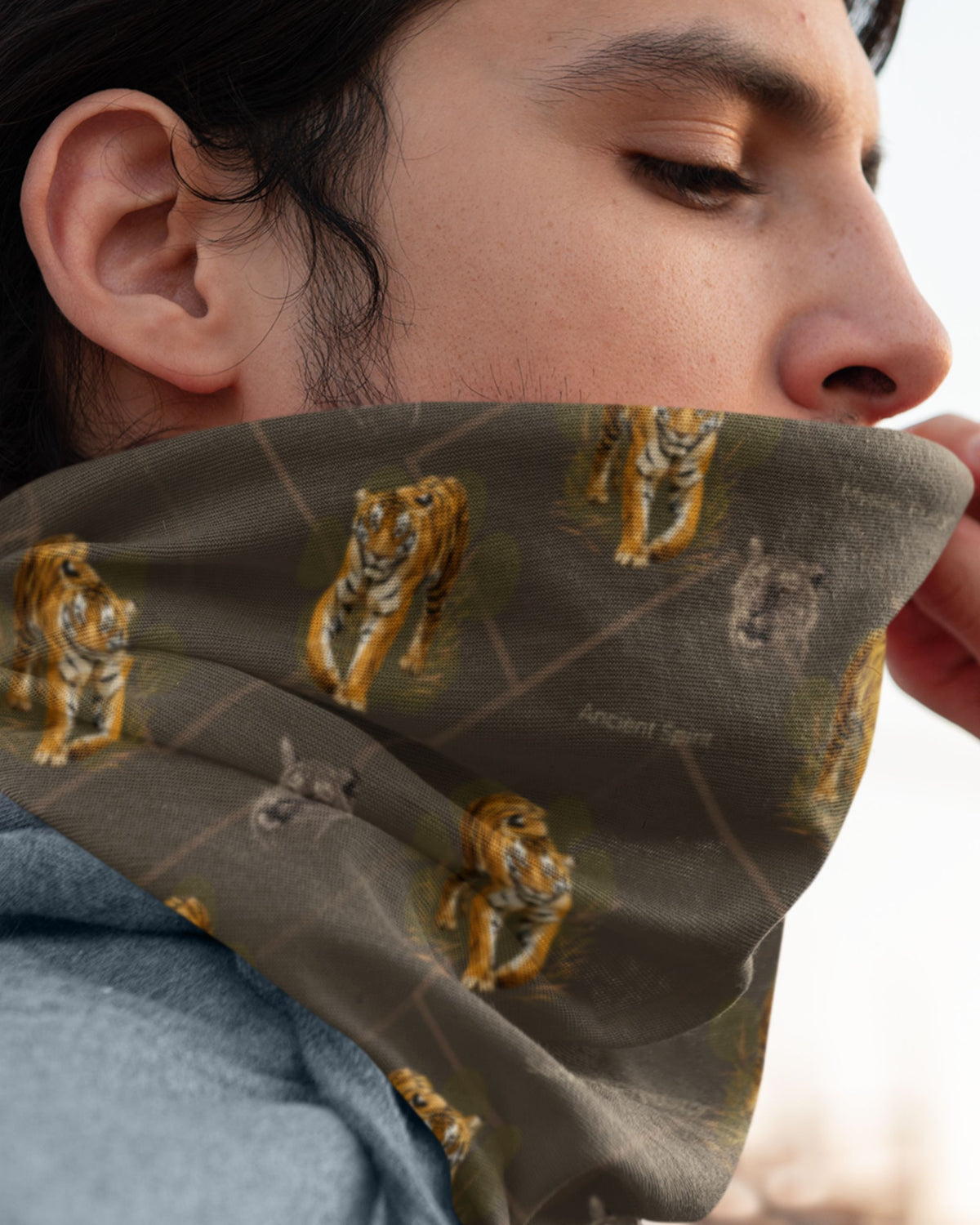 man wearing a Tiger Spirit Neck Gaiter with repeating tiger and wildlife print