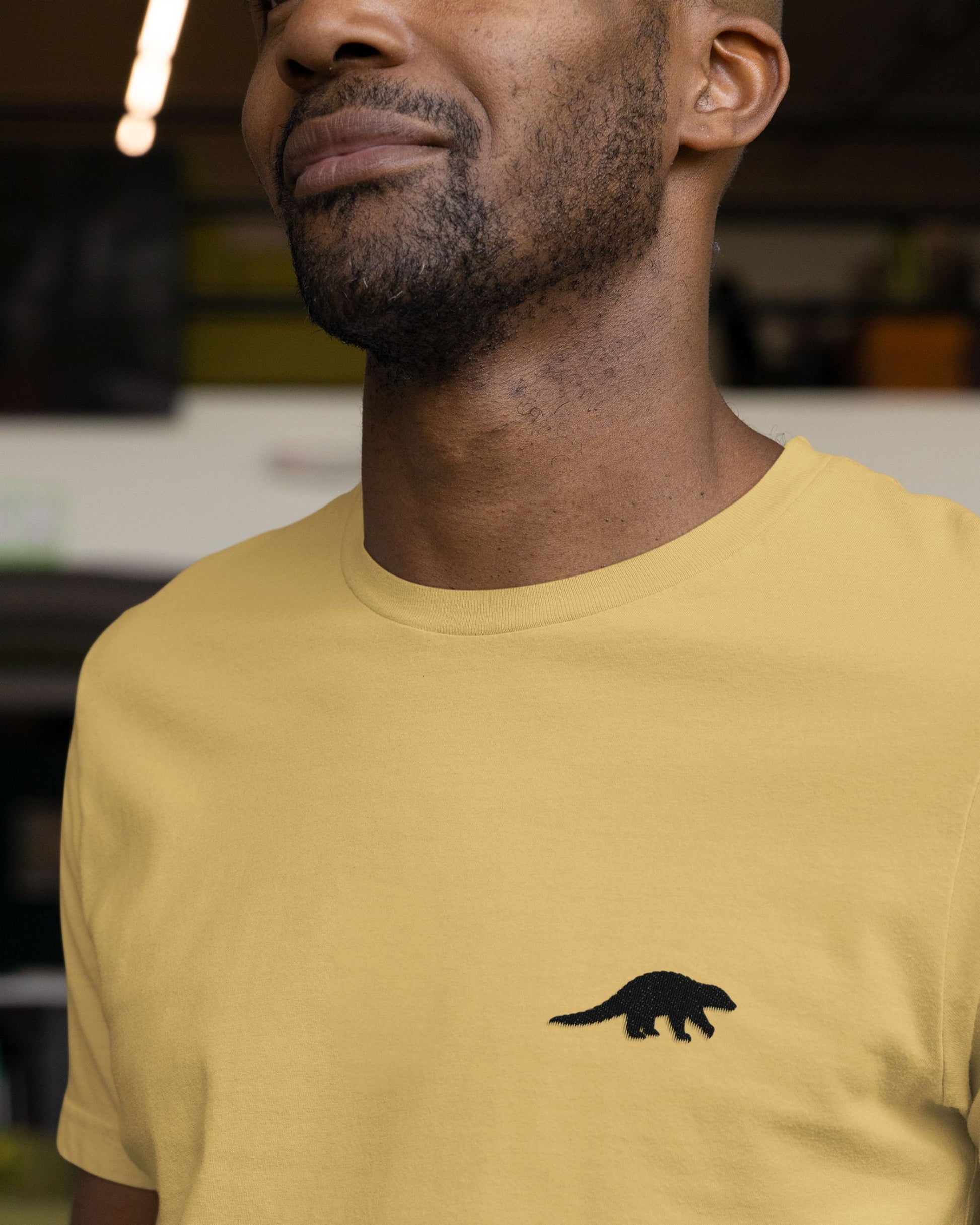 Model wearing Beige Supima cotton t-shirt with embroidered Indian Pangolin wildlife design by Tucktribe