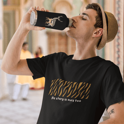 Man drinking from a black water bottle with a design, wearing a black t-shirt with text and graphics.