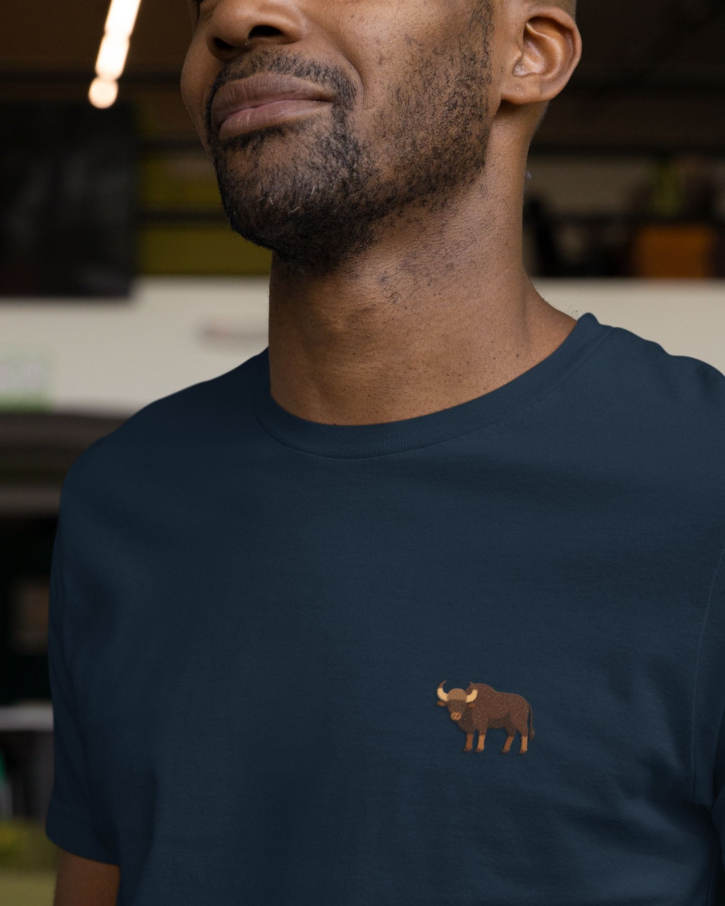 man wearing navy blue Supima cotton t-shirt with embroidered Indian Gaur wildlife design by Tucktribe