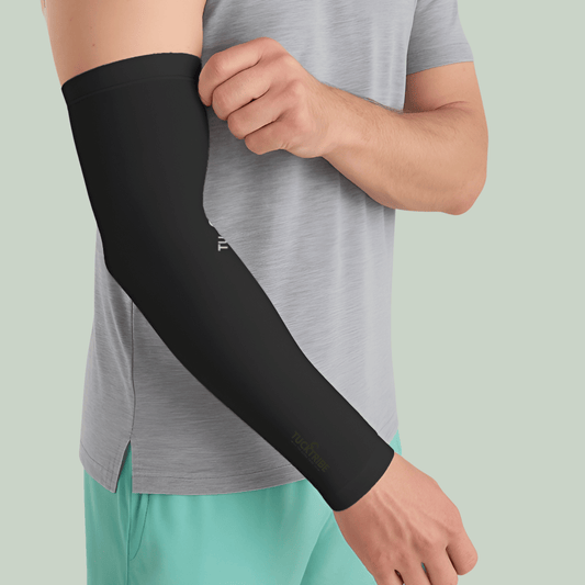 Person wearing a Tucktribe charcoal Black arm sleeve on a light green background