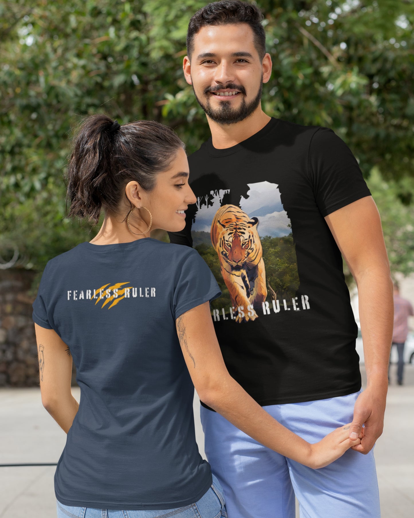 Man wearing a black tshirt with Tiger graphics on it and women wearing a navy blue tshirt with text FEARLESS RULER written on the back