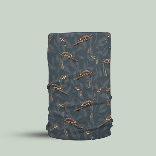 A tubular neck gaiter or face mask featuring a repeating pattern of grizzled giant squirrel with white accents over a dark slate blue-gray background, shown on a solid light sage green backdrop.