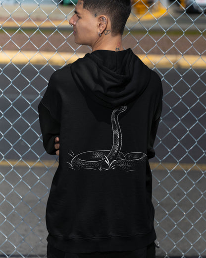 man wearing a Black tucktribe unisex hoodie featuring detailed cobra snake artwork on the back for wildlife lovers.