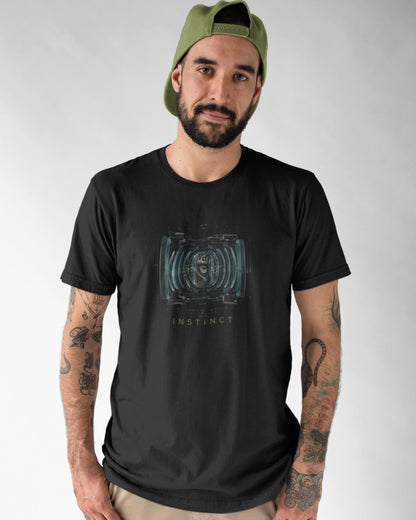 Man wearing a black tucktribe t-shirt with a graphic design and text, standing against a plain background