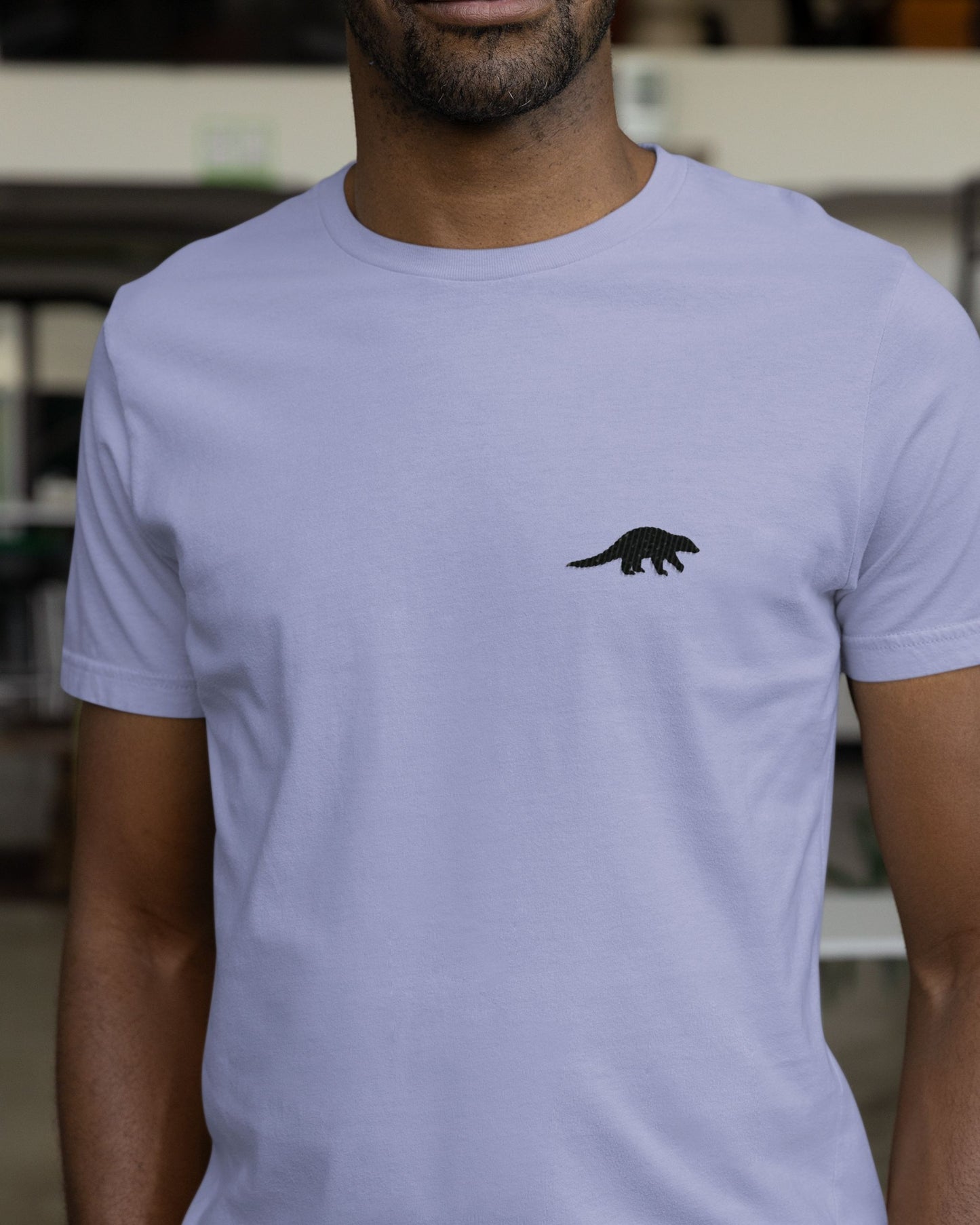 Model wearing lavender Supima cotton t-shirt with embroidered Indian Pangolin wildlife design by Tucktribe