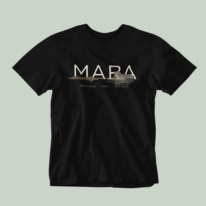 A black Tucktribe short-sleeve crewneck t-shirt with a beige graphic print on the chest featuring the word 'MARA' and smaller text 'PREDATOR - PREY- BALANCE' with a Zebra and crocodile illustration, displayed against a solid light sage green background.