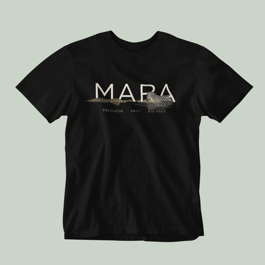 A black Tucktribe short-sleeve crewneck t-shirt with a beige graphic print on the chest featuring the word 'MARA' and smaller text 'PREDATOR - PREY- BALANCE' with a Zebra and crocodile illustration, displayed against a solid light sage green background.