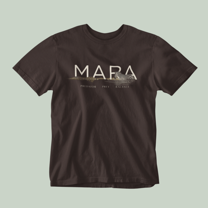 A brown Tucktribe short-sleeve crewneck t-shirt with a beige graphic print on the chest featuring the word 'MARA' and smaller text 'PREDATOR - PREY- BALANCE' with a Zebra and crocodile illustration, displayed against a solid light sage green background.