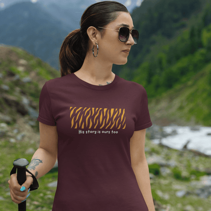 Woman wearing a t-shirt with a tiger stripe design and text, standing in a mountainous landscape.