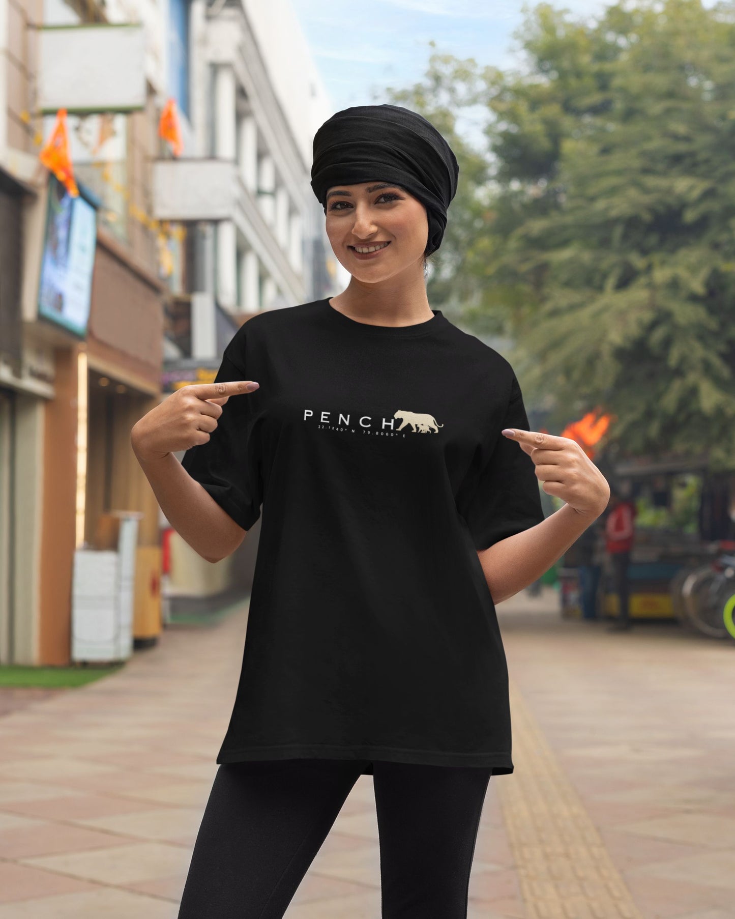 Woman wearing Black t-shirt with PENCH typography and tiger silhouette print inspired by Pench Tiger Reserve