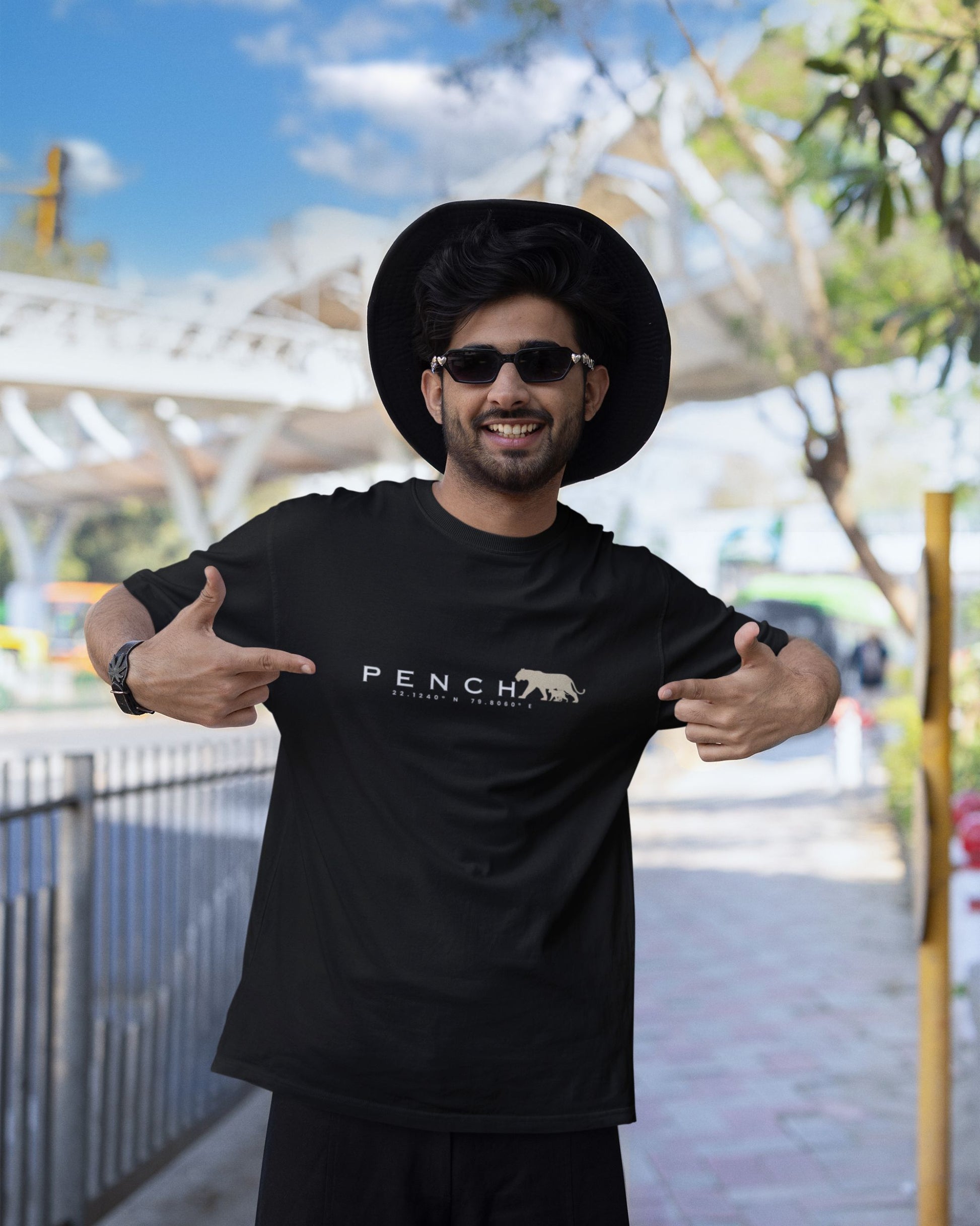 Man wearing Black t-shirt with PENCH typography and tiger silhouette print inspired by Pench Tiger Reserve