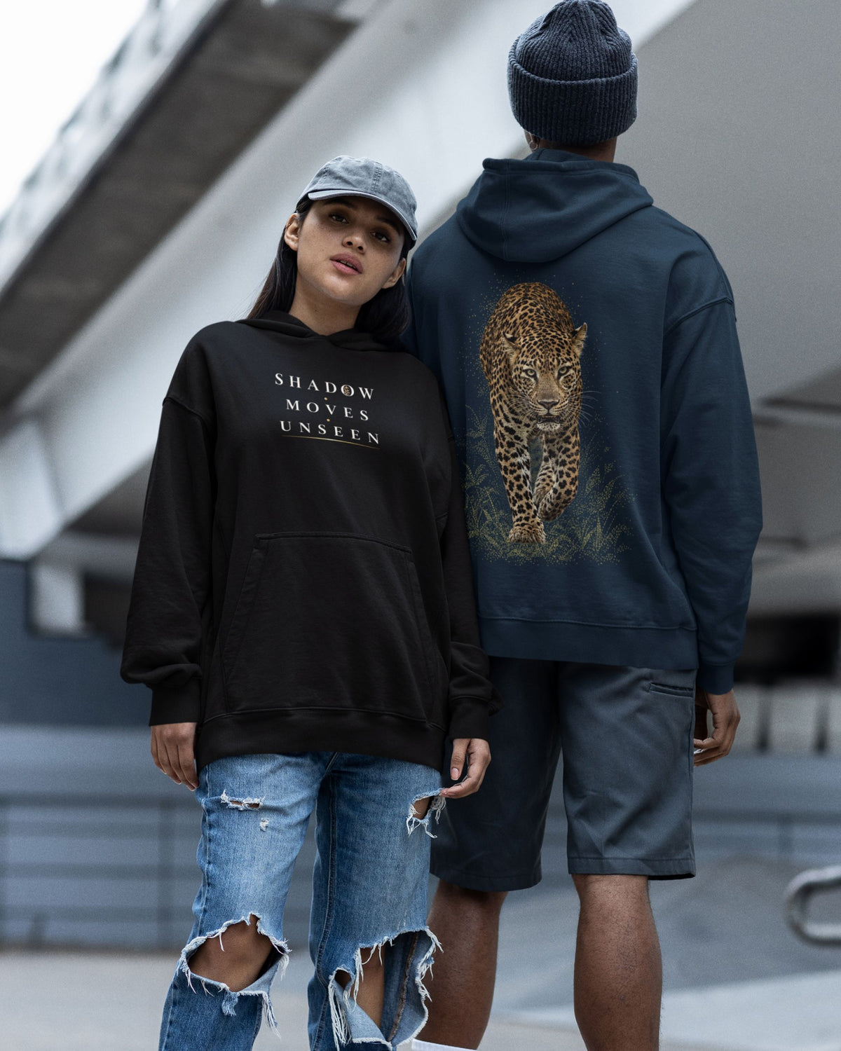 man and woman wearing a black and navy blue Oversized unisex leopard hoodie with detailed back wildlife graphic and Shadow Moves Unseen front design