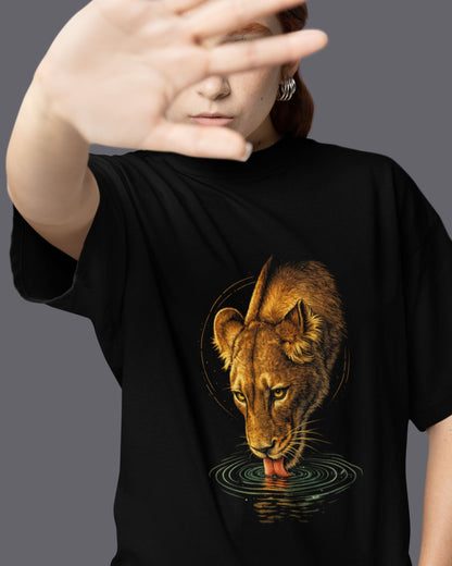 Person wearing a black tucktribe t-shirt with a lioness graphic design on a gray background
