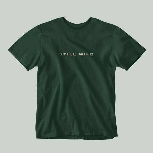 Bottle Green tucktribe t-shirt with 'STILL WILD' text on a light gray background