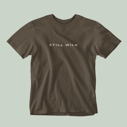 Brown tucktribe t-shirt with 'STILL WILD' text on a light green background
