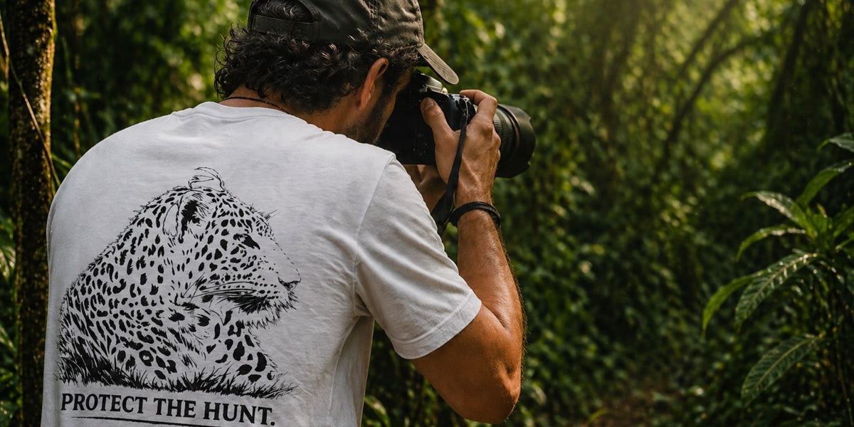 A wildlife photographer wearing a Tucktribe T-shirt with a leopard design