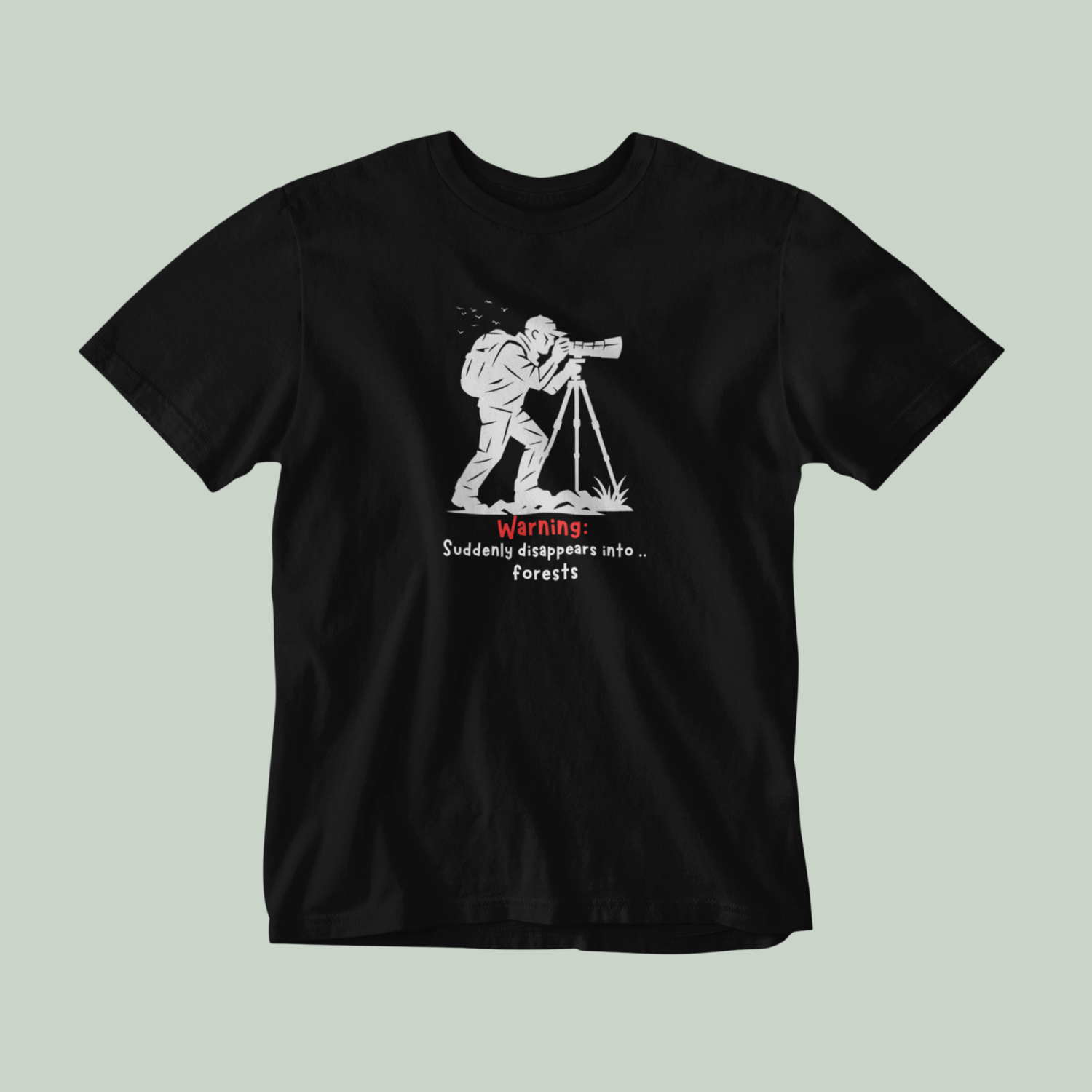 Black t-shirt with a graphic design of a person with a backpack and binoculars, and text on a light gray background.